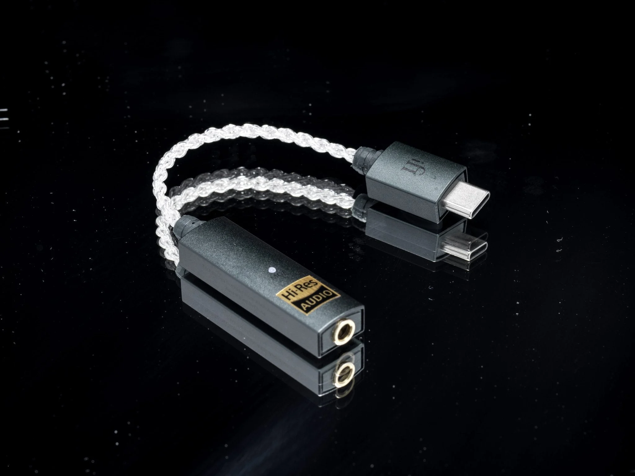 Portable DAC connected to earphones beside a smartphone